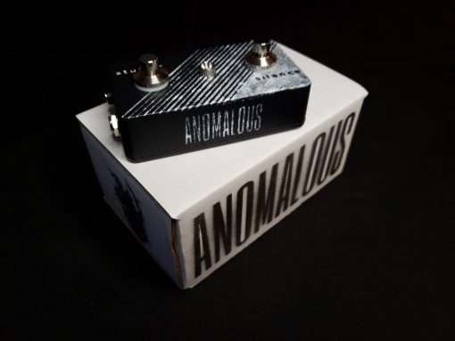 A photo of the Stutter Silence guitar pedal on top of an Anomalous-branded shipping box.